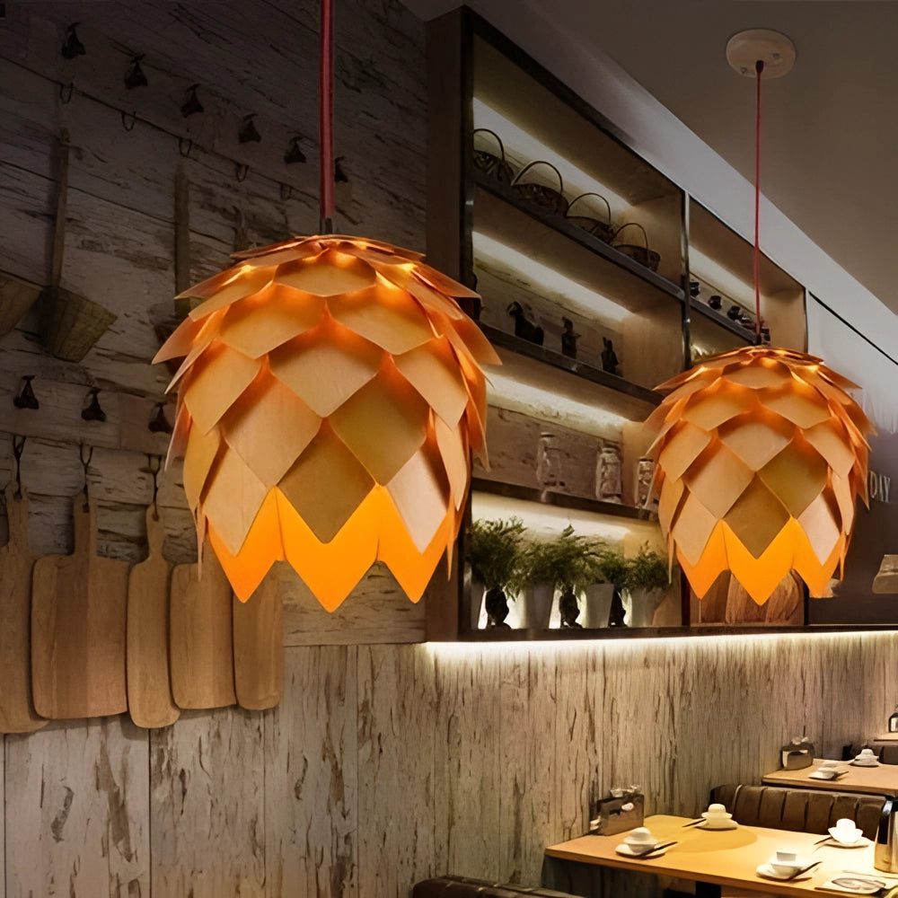 A modern Scandinavian pendant light with an organic pinecone-inspired design, featuring amber and orange tones, hanging from a ceiling in a stylish interior space.