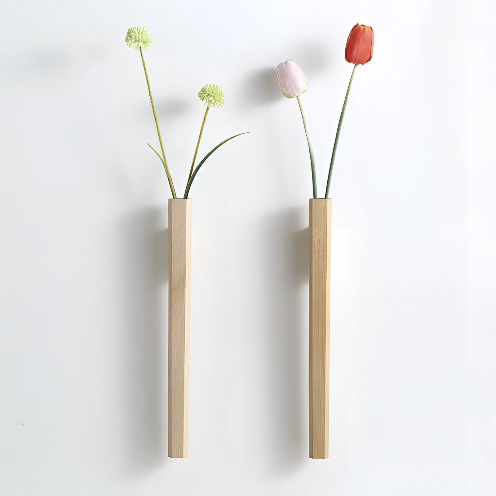 Minimalist Scandinavian wall-mounted wooden flower vase featuring a single artificial flower with delicate petals and a twig, designed as a creative vertical display piece.