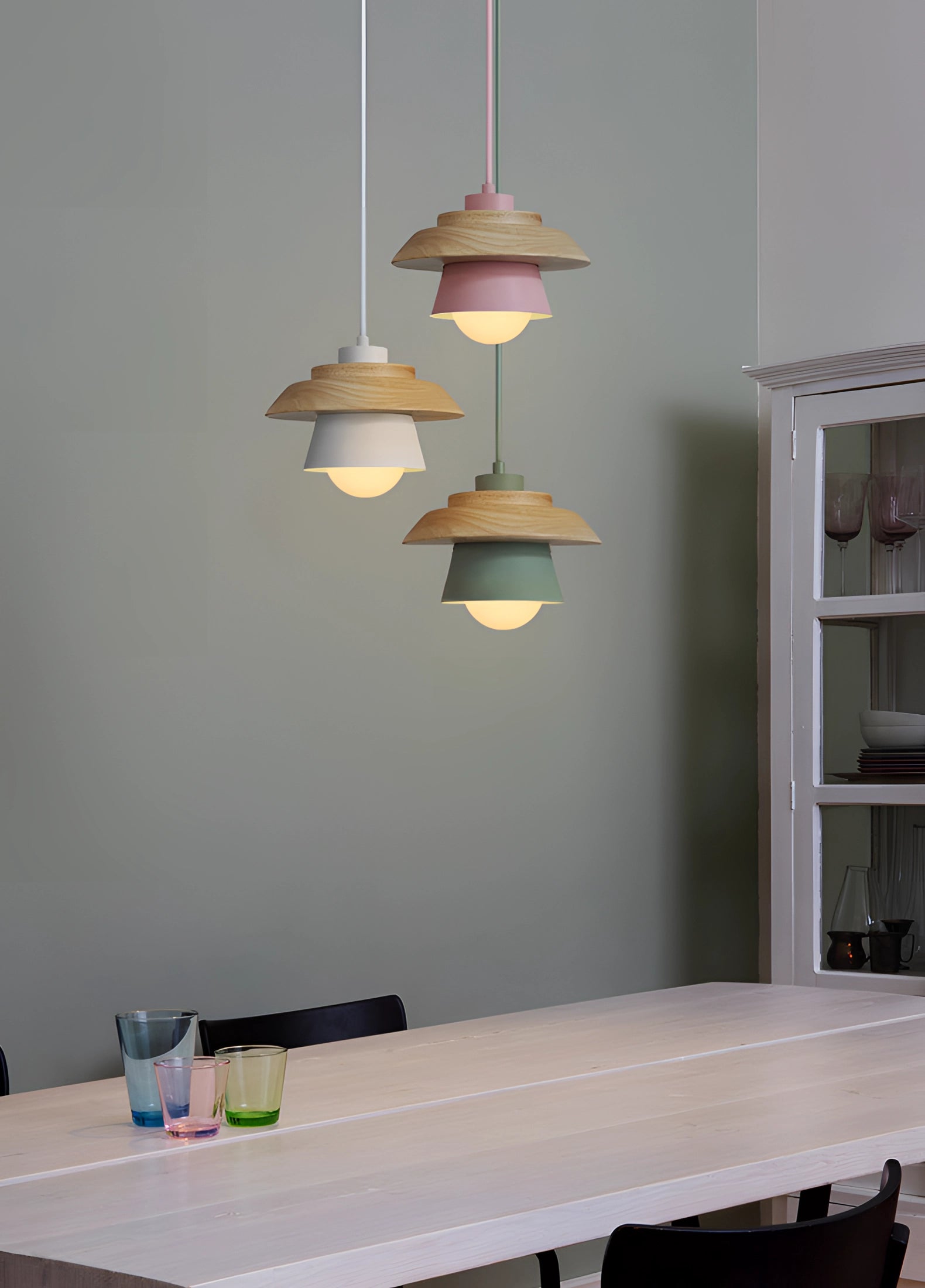 Scandinavian wooden pendant light featuring a modern, eco-friendly design, suspended from the ceiling in a stylish interior setting. The light is crafted from hardwood, showcasing natural wood tones and soft tints, complementing the surrounding minimalist decor.