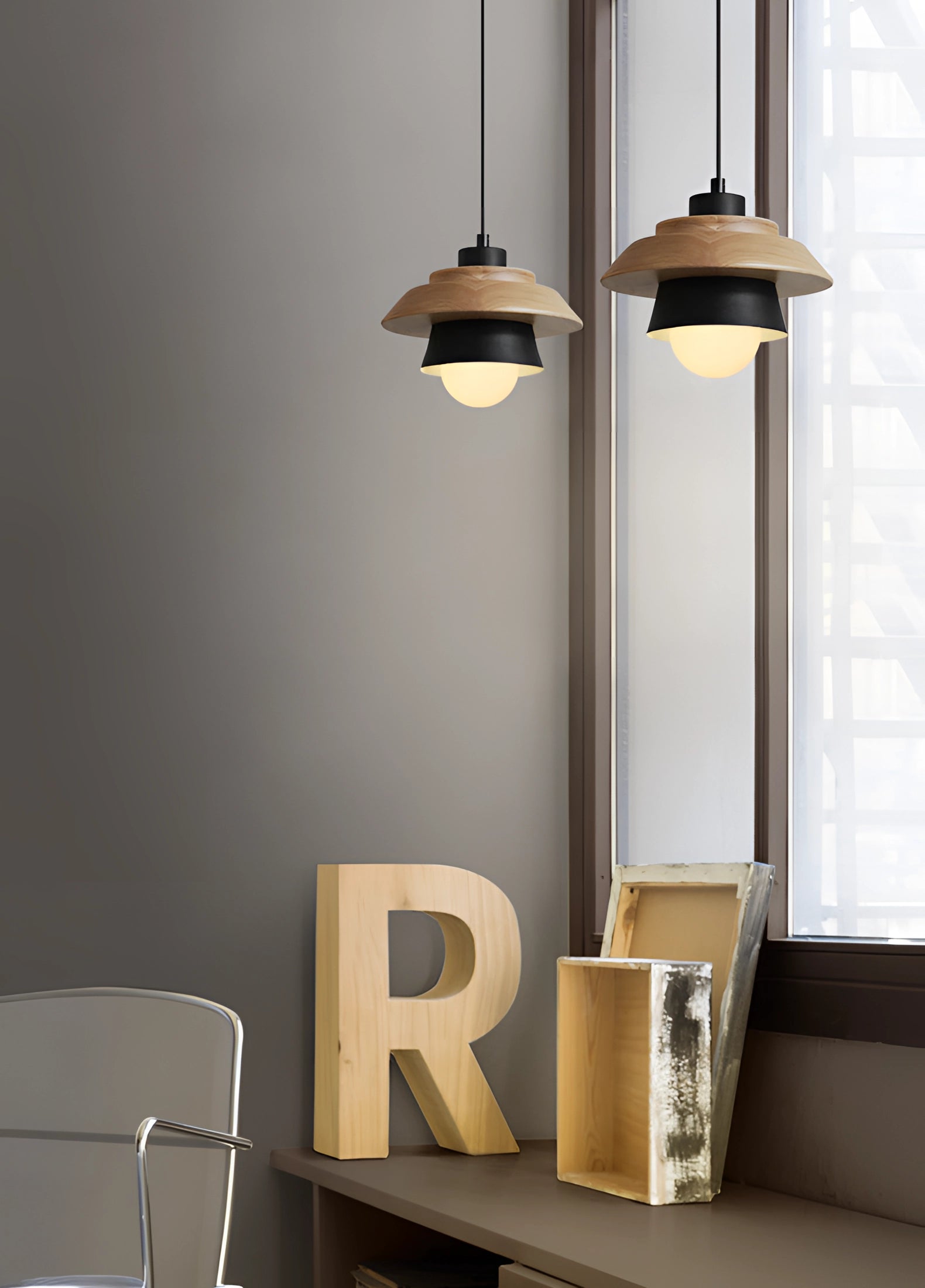 Scandinavian wooden pendant light with a black finish, featuring a modern rectangular design and eco-friendly materials, suspended from the ceiling in a stylish interior setting.