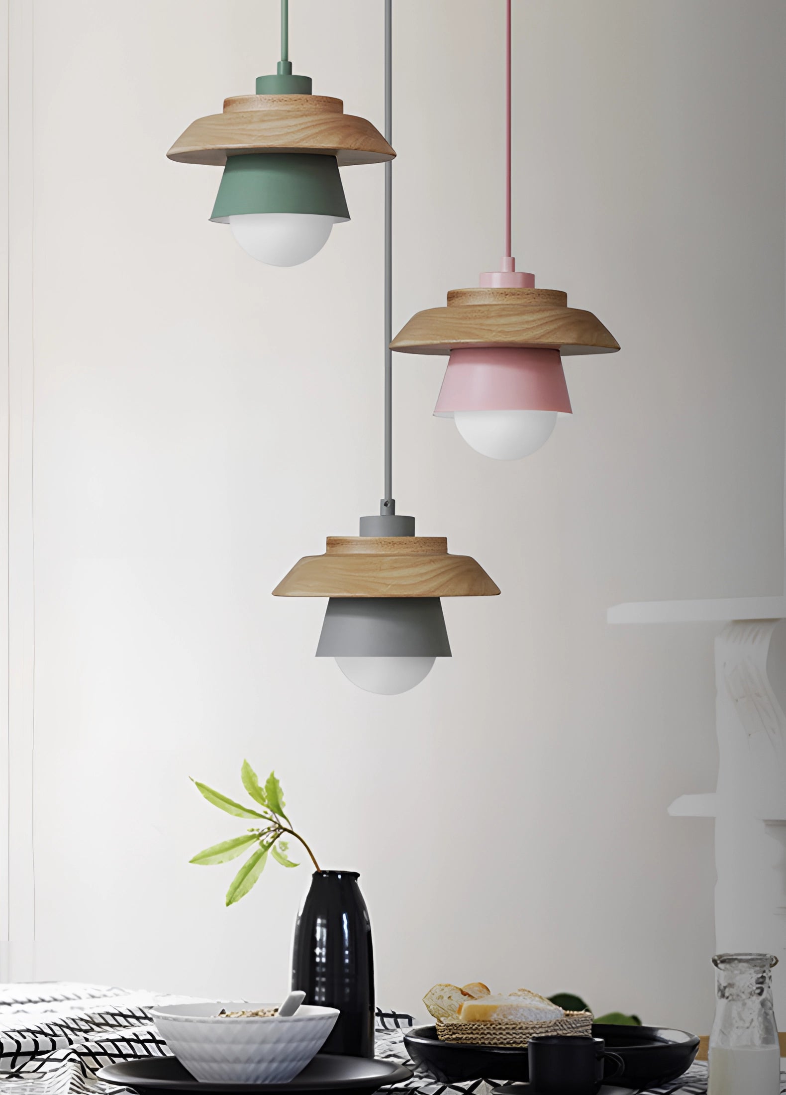 Modern Scandinavian eco-friendly wooden pendant light in green, hanging from the ceiling, illuminating a stylishly designed interior with a blend of white, grey, and yellow elements, complemented by natural wood accents and a nearby plant against a neutral wall.