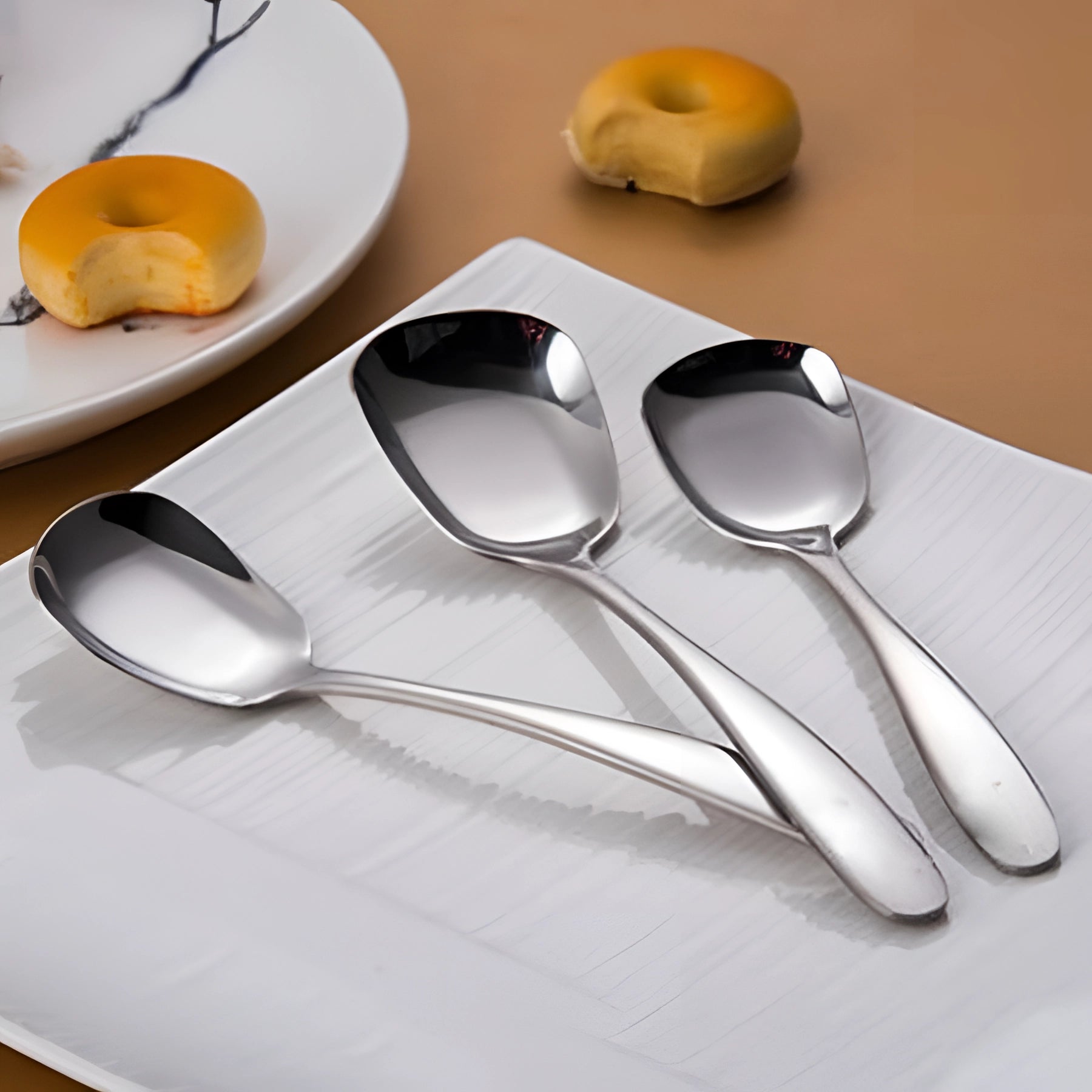 Sleek black stainless steel spoon set with a matte finish displayed alongside a silver variant, featuring modern design ideal for contemporary dining settings.