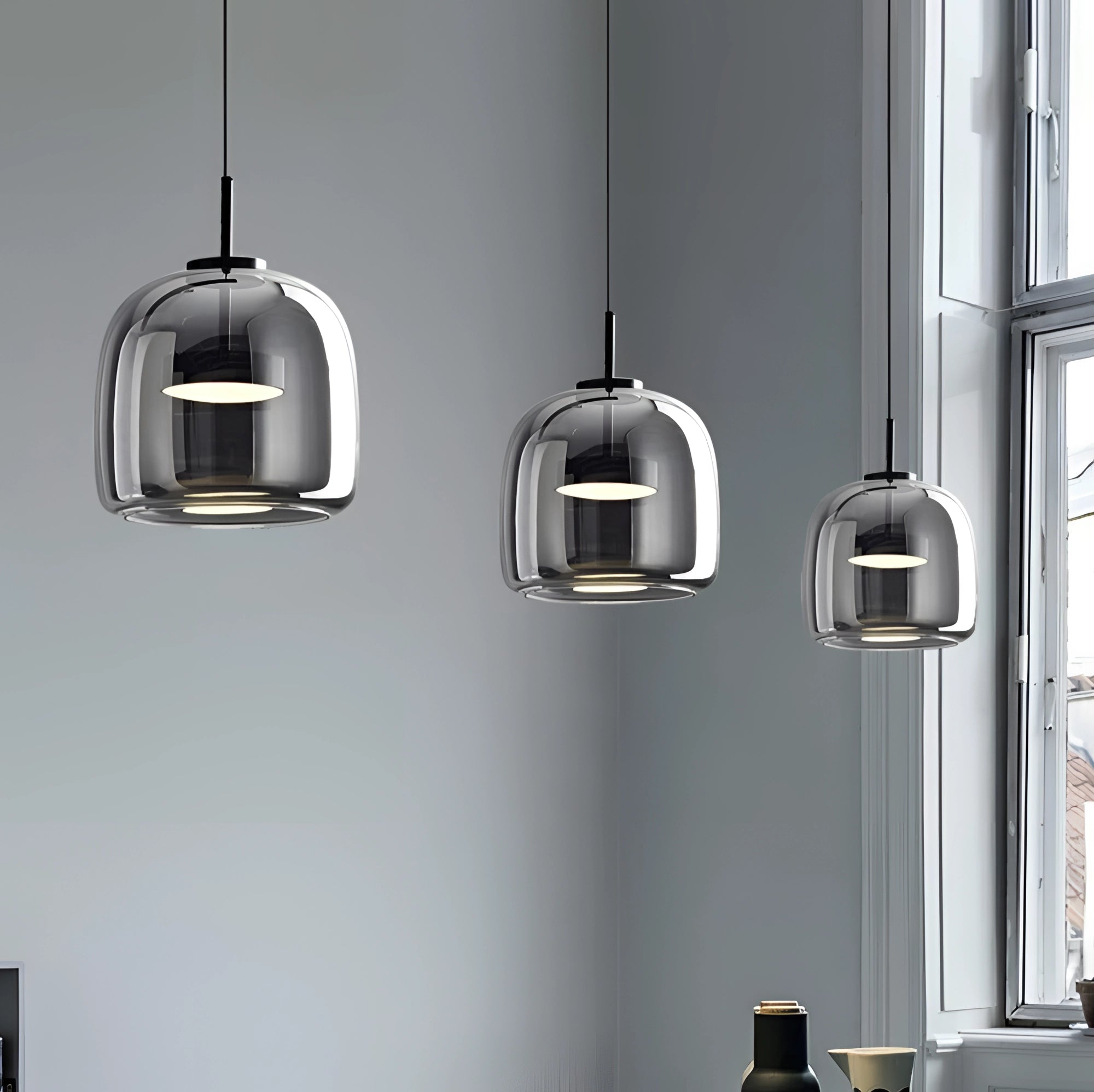 Smoked glass pendant light with minimalist industrial design, featuring a sleek metal fixture, ideal for kitchen lighting.