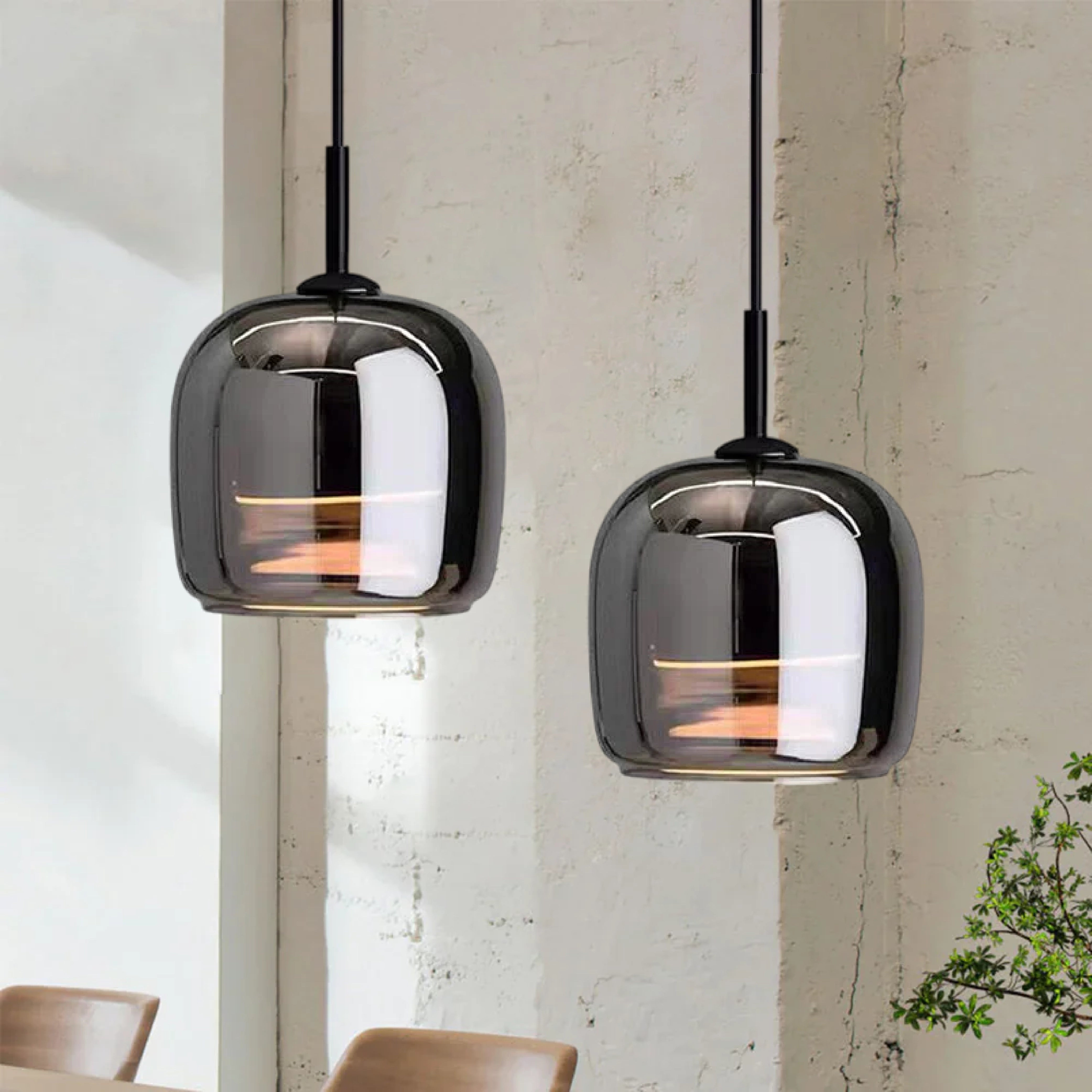 Minimalist industrial smoked glass pendant light with wooden accents hanging in a modern kitchen.