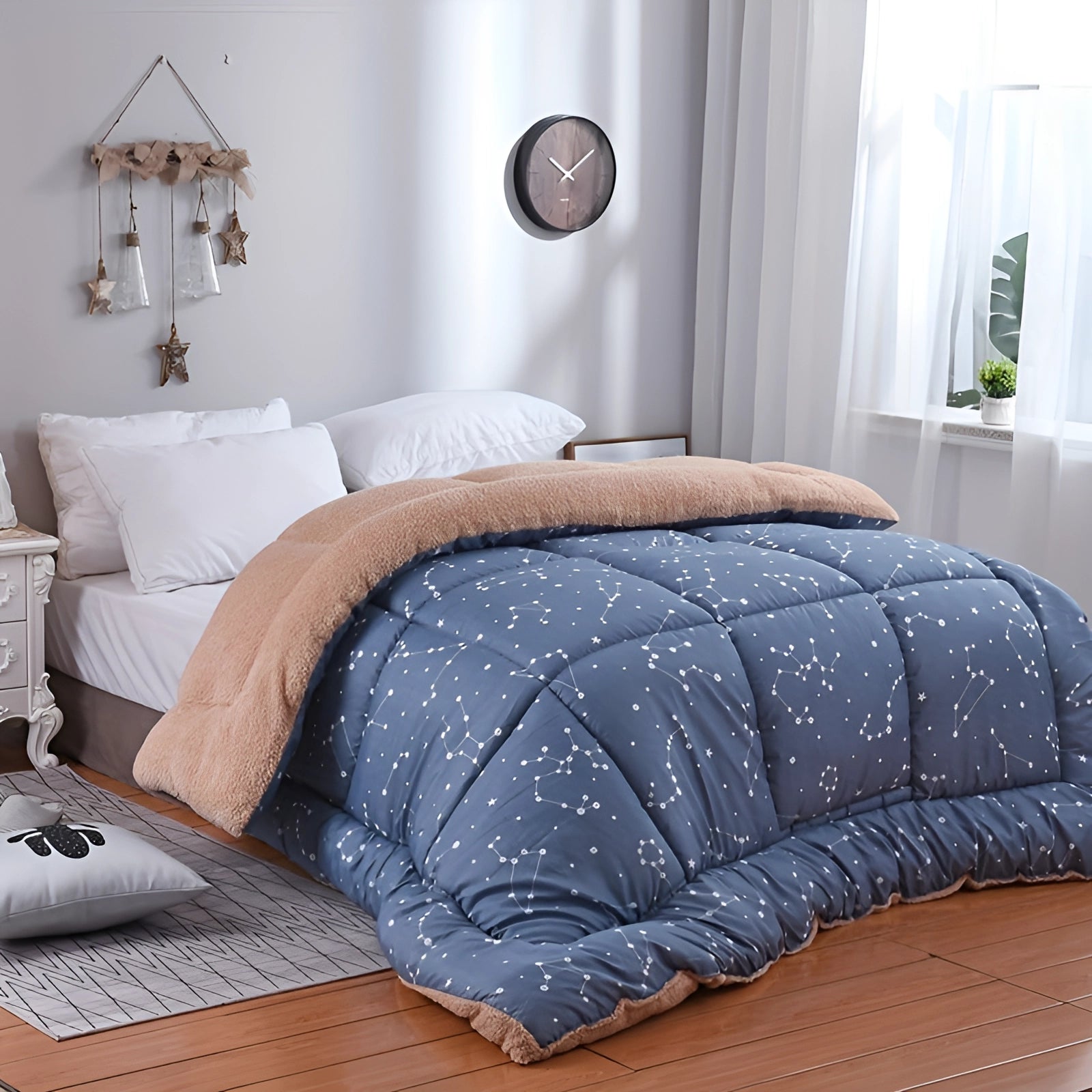 Weighted blanket with a blue star pattern draped over a bed in a well-designed interior room with grey walls and wooden floor.