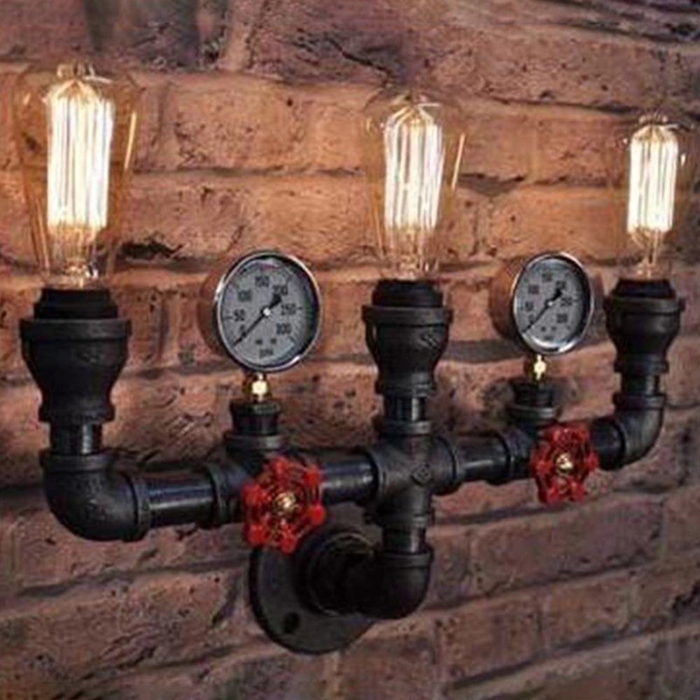 Steampunk industrial pipe wall lamp featuring an Edison bulb and decorative gauge, mounted on a wooden backplate with metal plumbing valve accents, evoking an antique and vintage aesthetic.