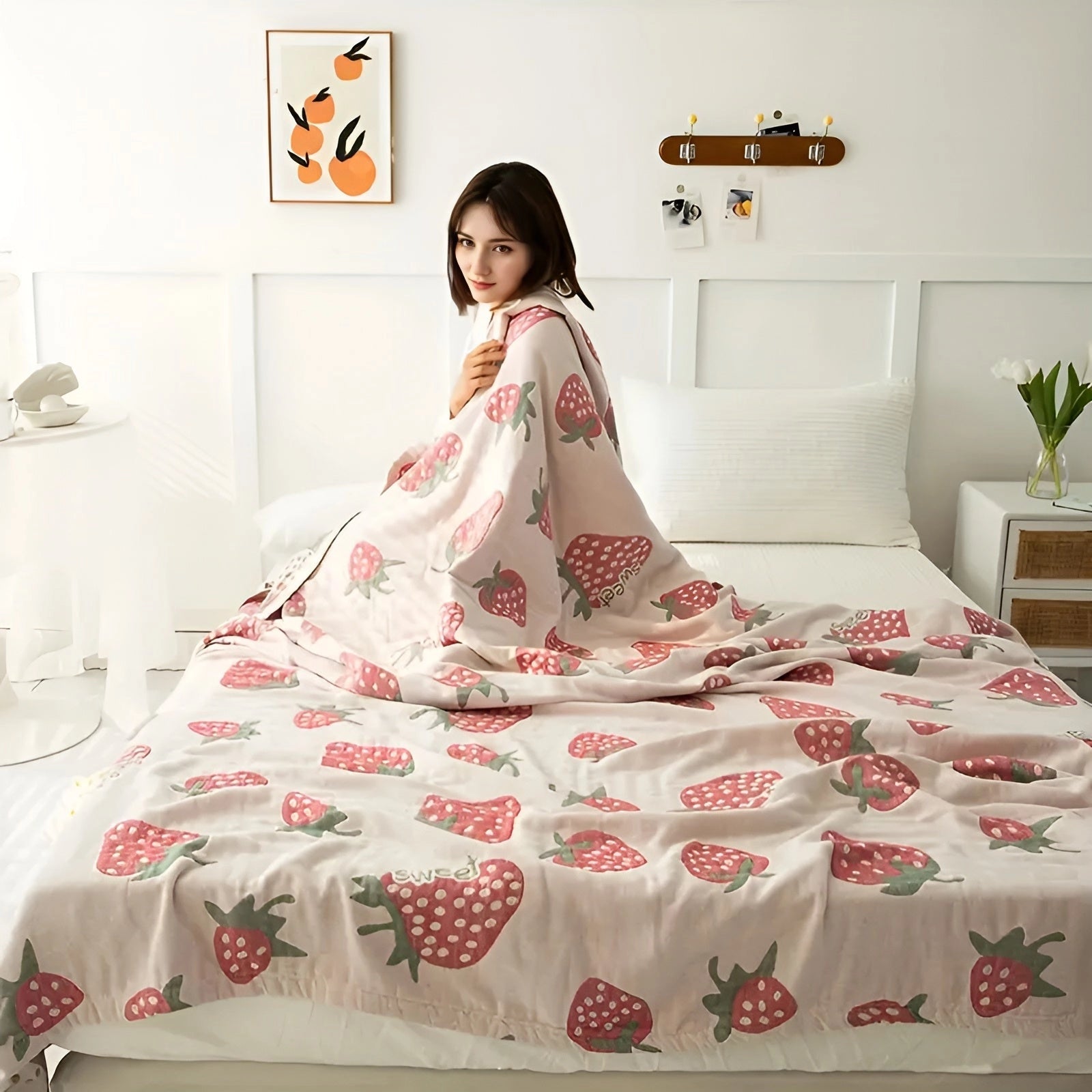 A soft blanket featuring a cute strawberry pattern, perfect for adding a playful touch to a bedroom or living room décor.