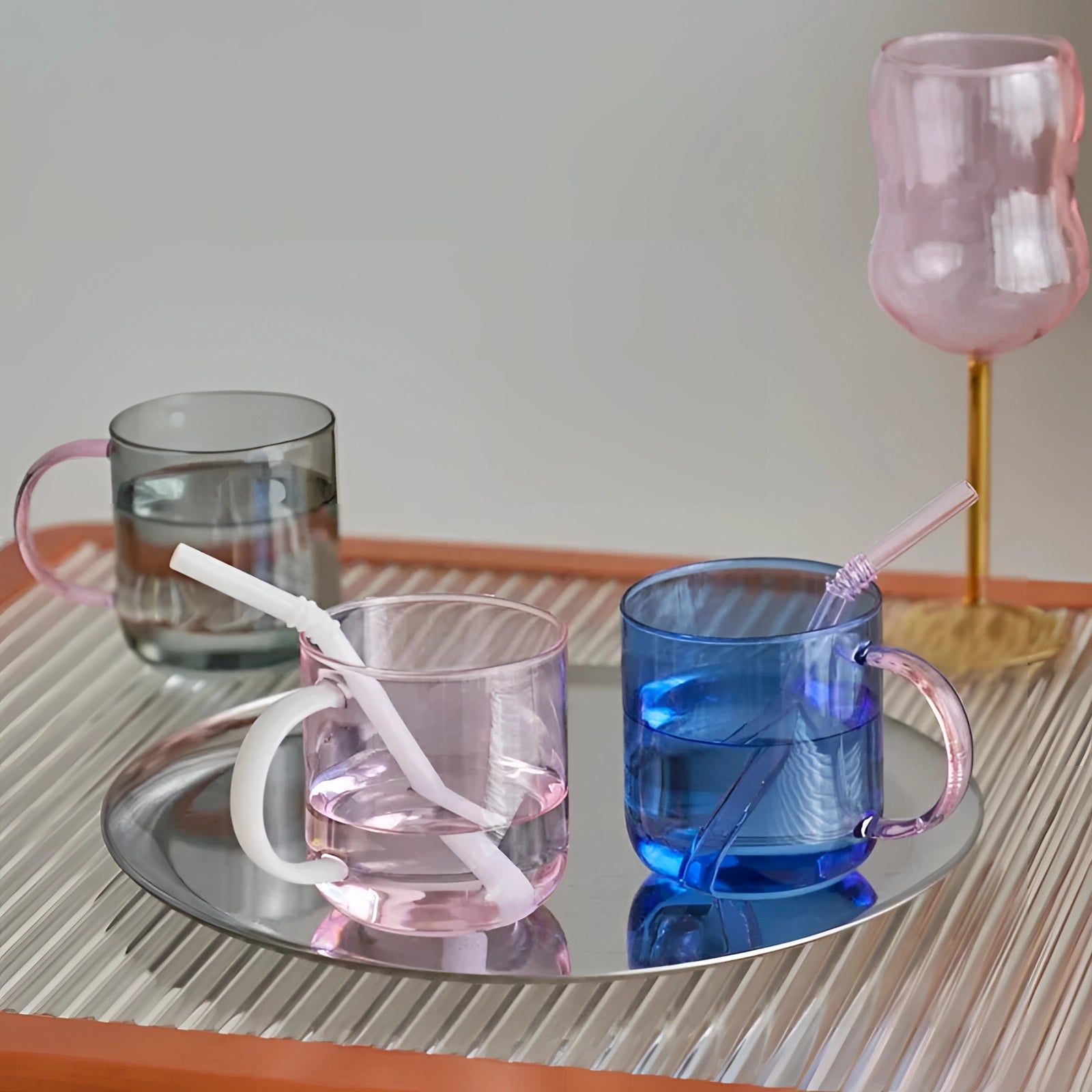 Stylish lightweight pink glass coffee and tea mugs on a table, showcasing unique and elegant glassware design.