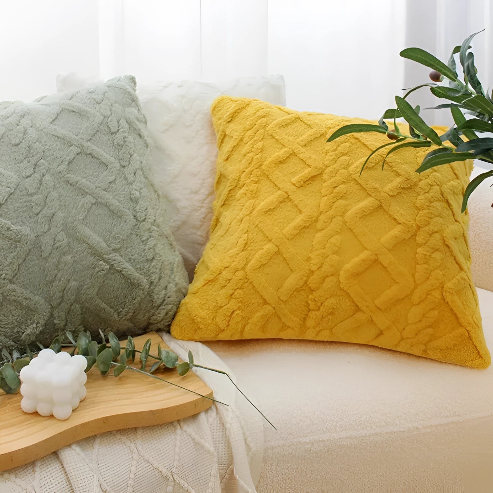 Multi-color geometric textured velvet throw pillows on a couch in a stylish interior design setting.