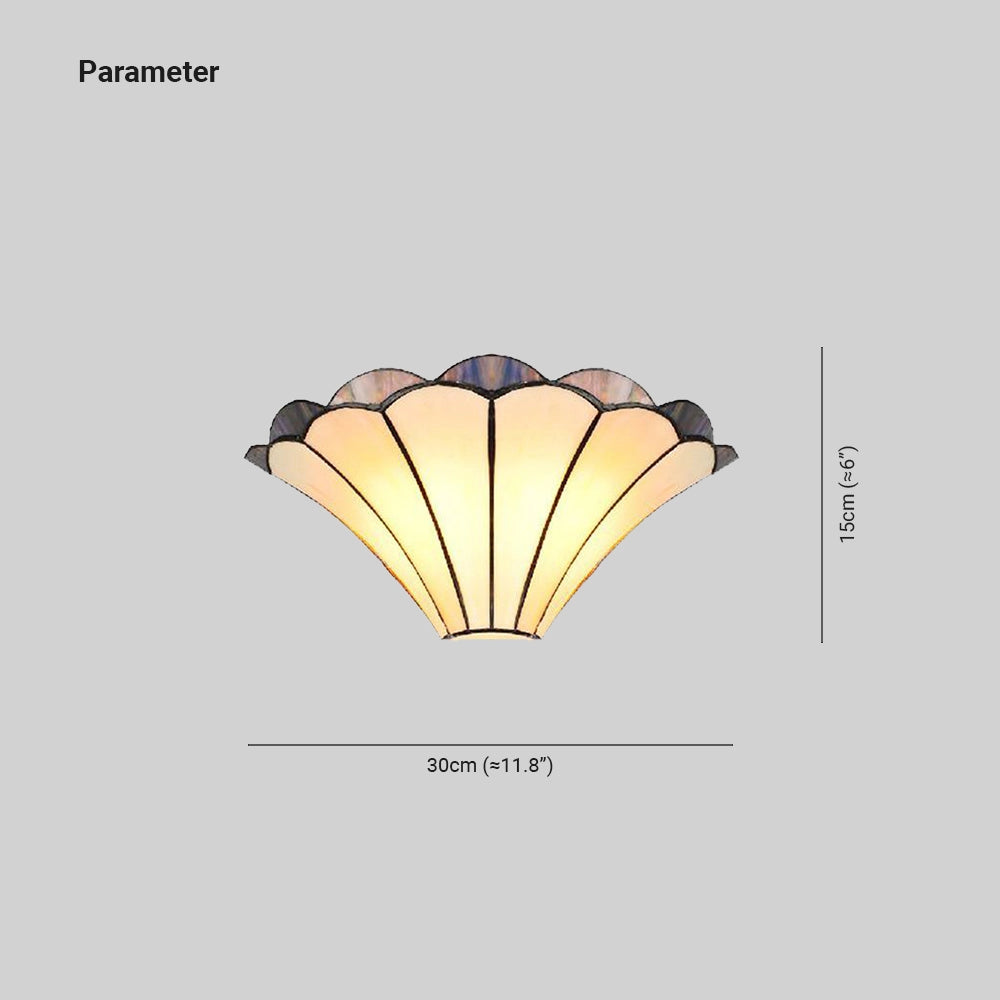 Tiffany-style stained glass wall sconce featuring a shell design with an Art Deco aesthetic, showcasing vibrant tints and shades in a symmetrical pattern.