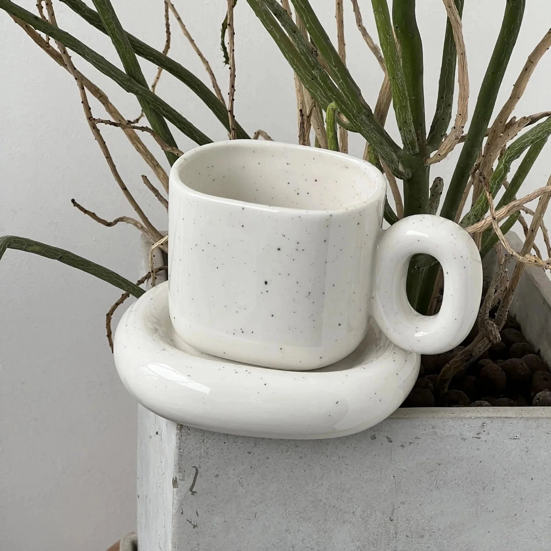 Turquoise ceramic mug with unique handle and a creamy white finish, modern designer coffee cup with a 280ml capacity.