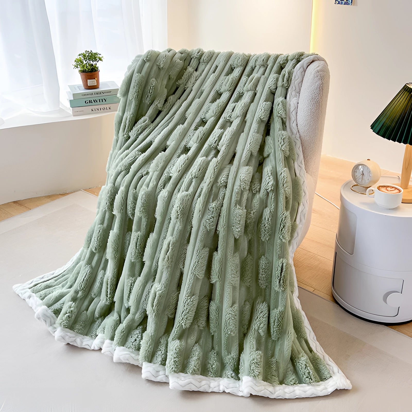 Turquoise chunky knit blanket draped over a hardwood floor, with a cozy plush braided texture, surrounded by subtle decor including a plant and art piece.