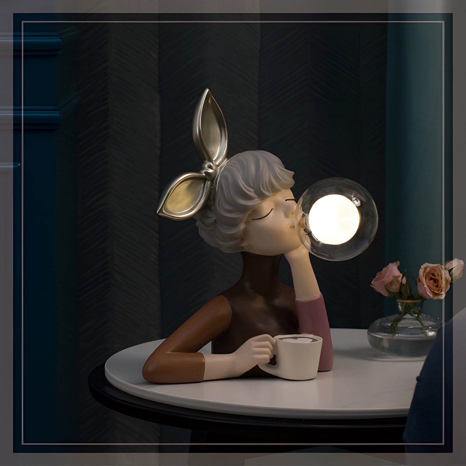 Whimsical ceramic bubble statue featuring shiny gold bunny ears, displayed on a table near a window.