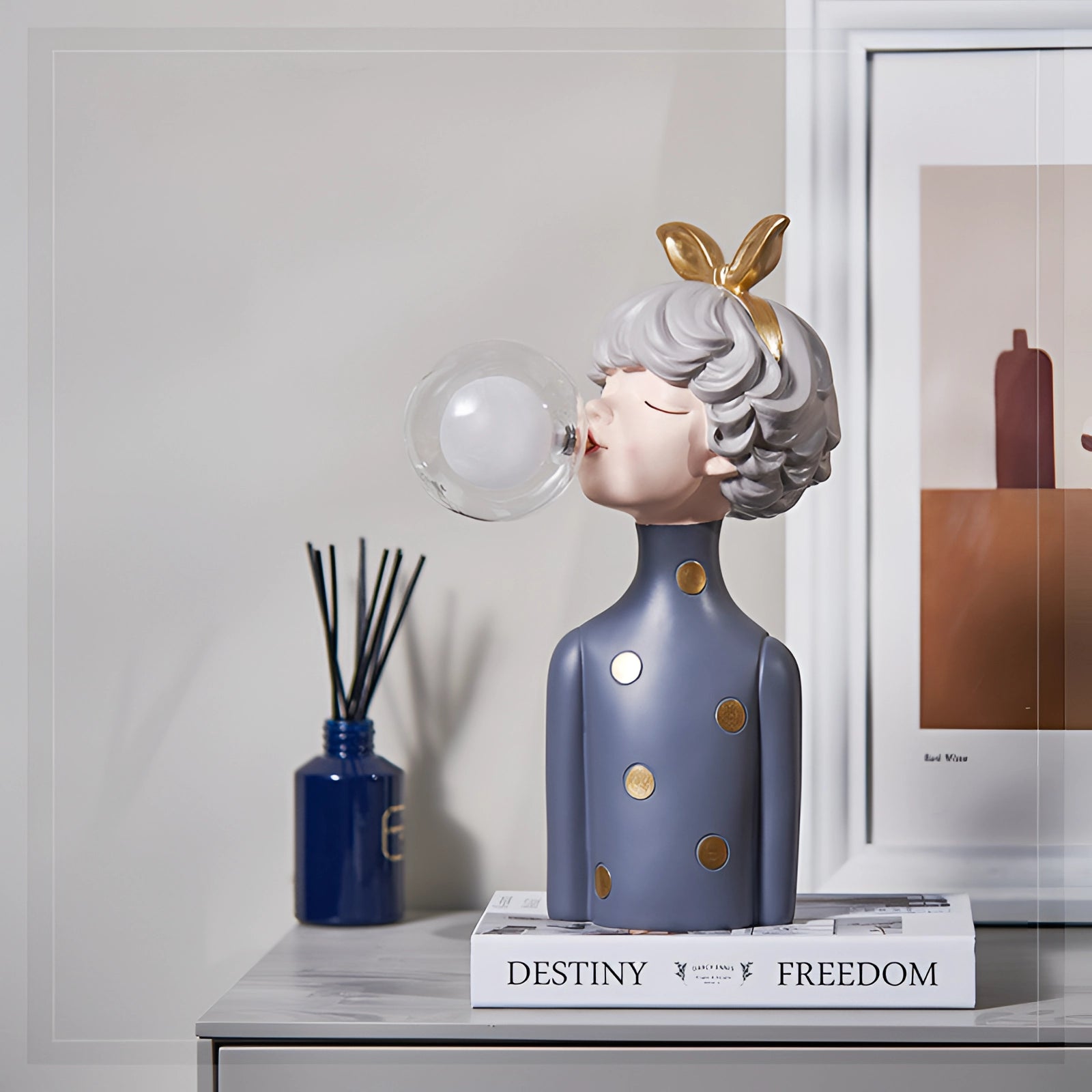 Whimsical ceramic bubble statue featuring gold bunny ears, displayed on a table in a stylish room setting.