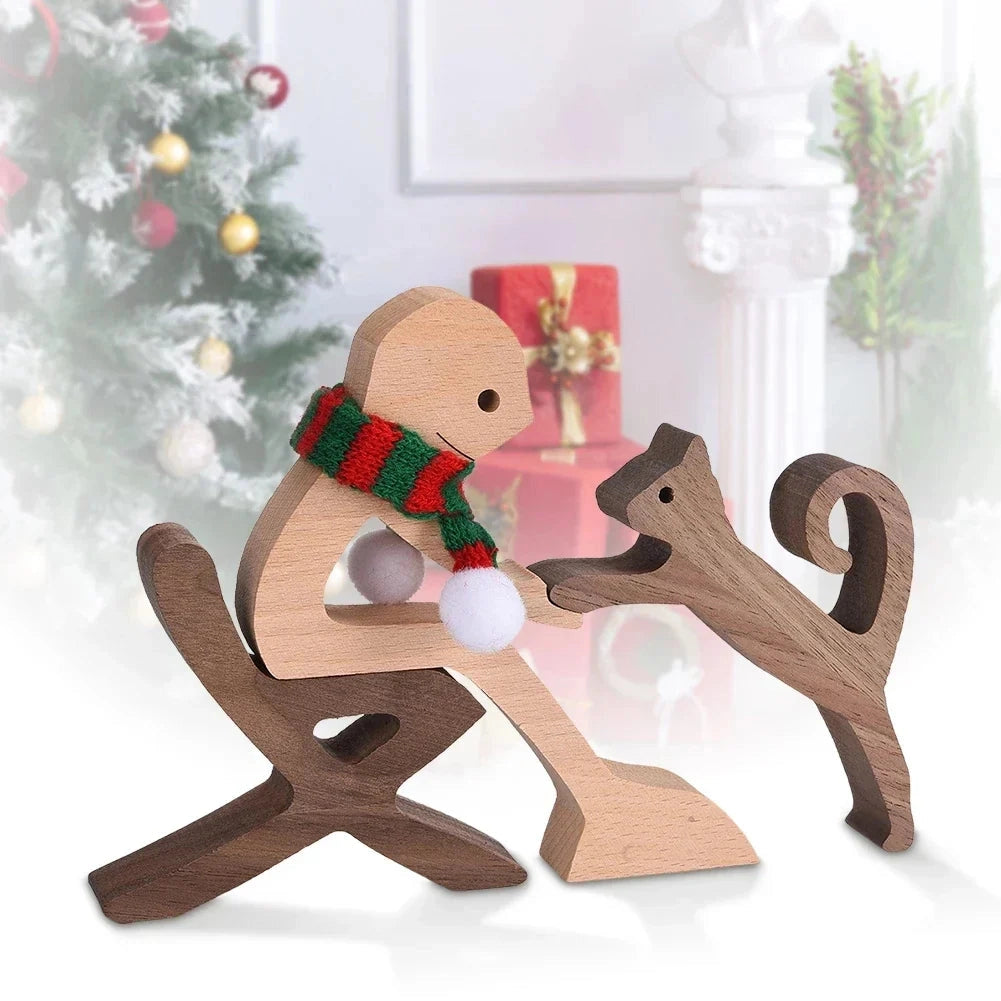 Wooden dog sculpture wearing a striped scarf, positioned in front of a festive Christmas tree, surrounded by holiday ornaments and decorations.