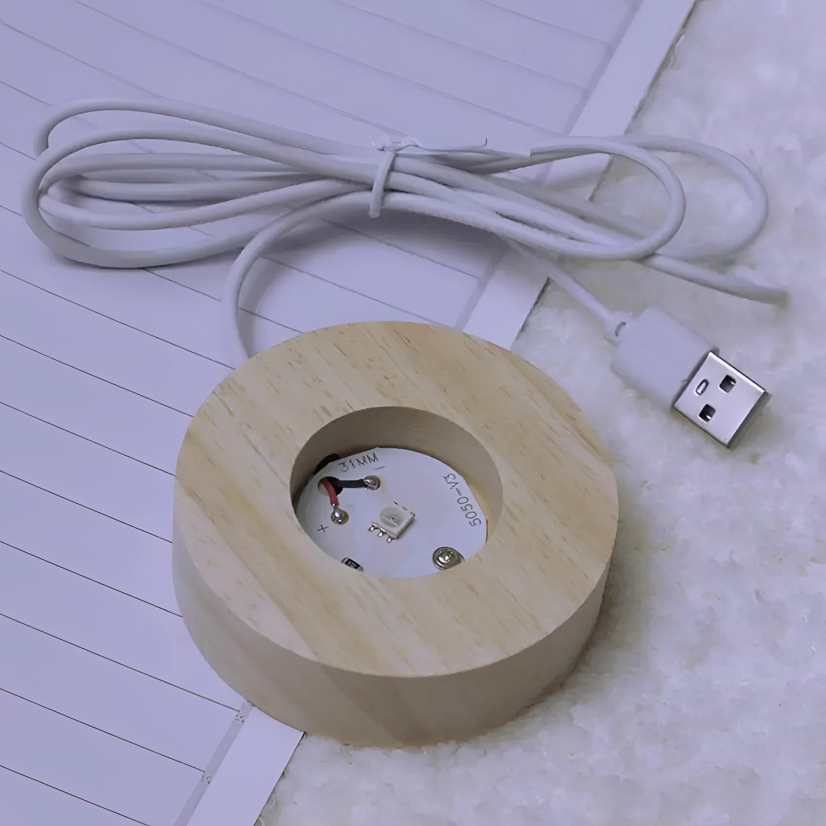 A wooden USB aroma diffuser with a circular design, featuring a port for connecting a cable, designed for diffusing essential oils in an eco-friendly manner.