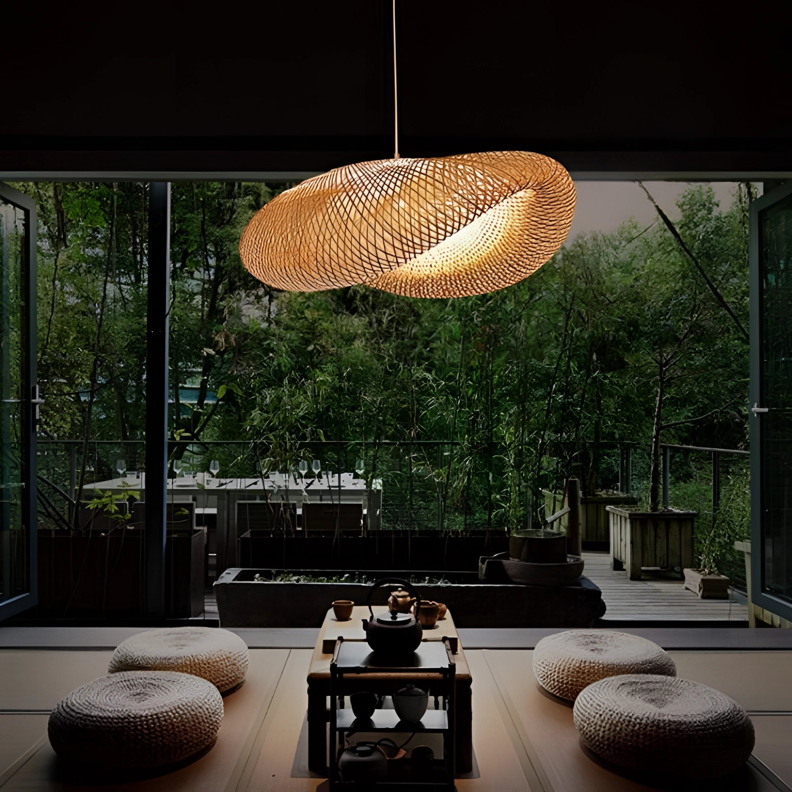 Handmade woven LED pendant light in natural fiber emitting warm white light, hanging over a table with a plant and tree in a cozy living room setting.