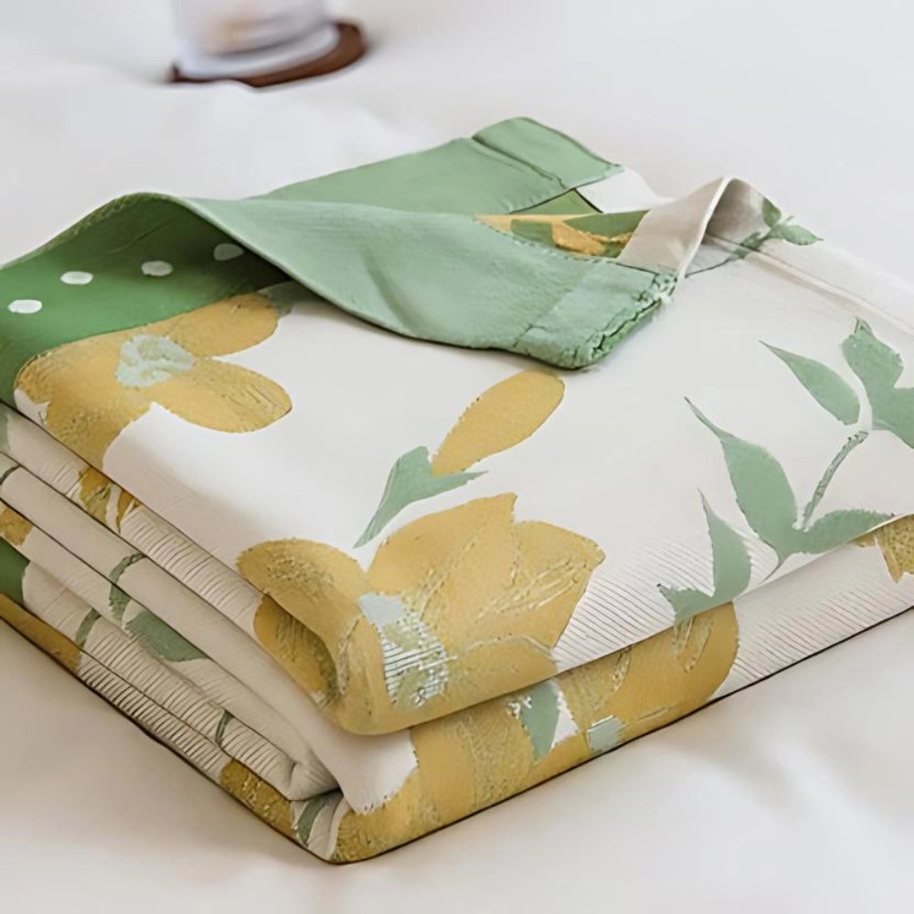 Yellow flower cooling blanket made of luxury cotton, featuring a botanical pattern and rectangular shape, displayed on a flat surface.