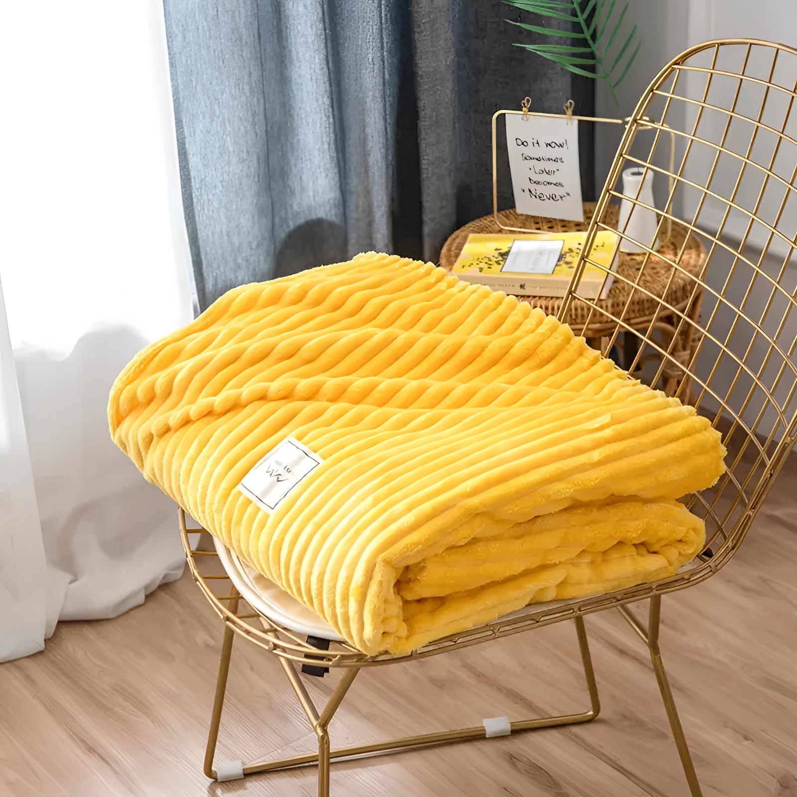 A cozy yellow ribbed blanket draped over an outdoor wooden chair, set against a hardwood floor, enhancing modern bedroom decor.