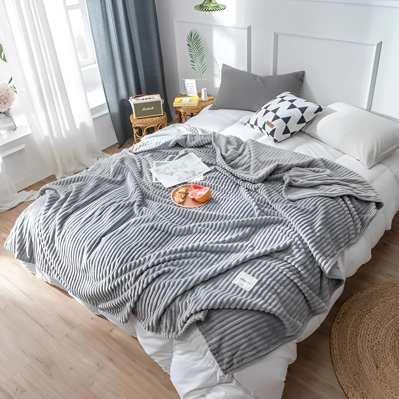 Yellow ribbed blanket in gray, draped over a bed in a modern bedroom setting, complemented by wooden flooring, a houseplant, and minimalist decor.