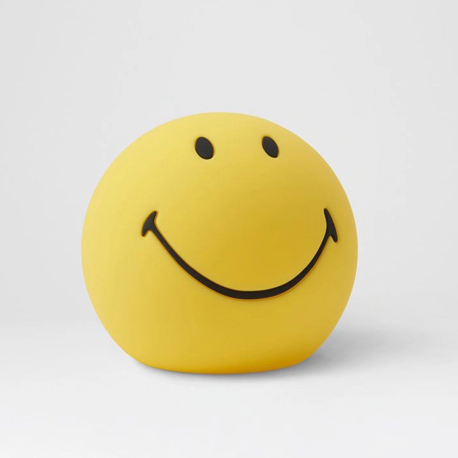 Yellow smiley face stress ball with a happy expression, featuring large black eyes and a wide smile, resembling a classic emoji.